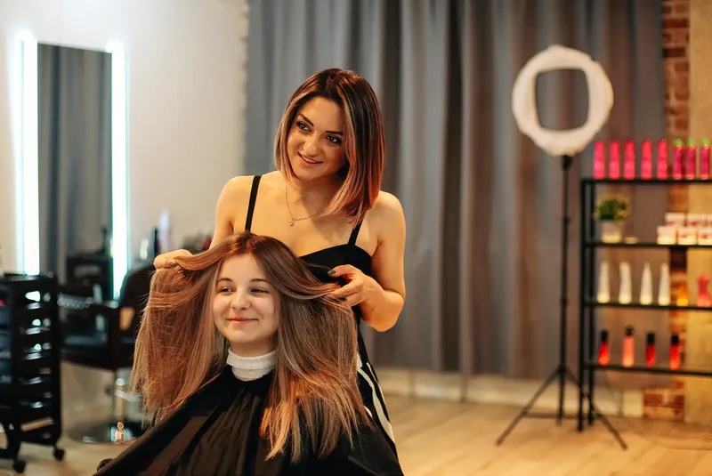 Hairdresser talking with a smiling client in a bright salon