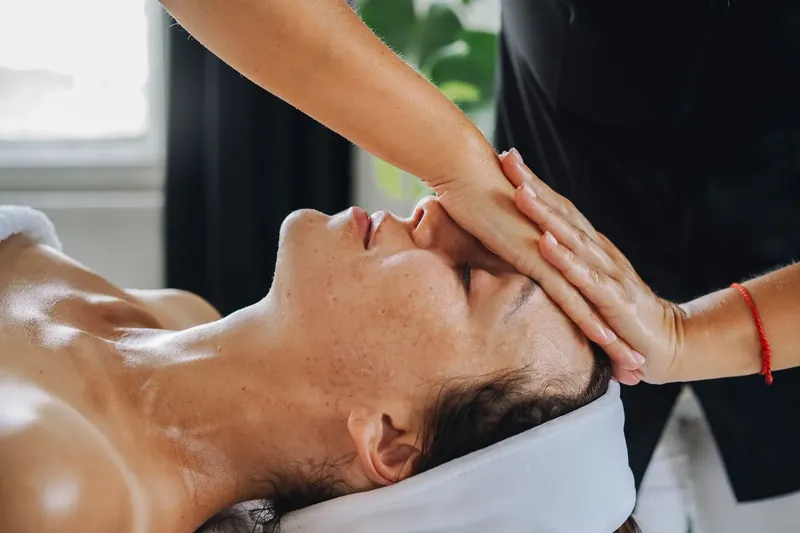 Therapist performing a facial treatment on a relaxed client